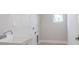 Clean laundry room features utility sink, window and clean white walls at 4880 Cornsilk Ter, North Port, FL 34286