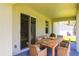 Covered patio with wood dining table, wicker chairs and a view of the backyard at 4880 Cornsilk Ter, North Port, FL 34286
