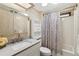 Bathroom features a shower-tub combo, neutral tones, a sink with a silver faucet, and a decorative mirror at 58 Lakeview Dr, North Port, FL 34287