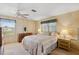 Cozy bedroom featuring a queen-sized bed, ceiling fan, and natural light from the window at 58 Lakeview Dr, North Port, FL 34287