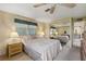 Bedroom with mirrored closet, side tables with lamps, and a ceiling fan at 58 Lakeview Dr, North Port, FL 34287