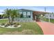 Charming home featuring a well-maintained yard with palm trees, a covered porch, and a vibrant painted driveway at 58 Lakeview Dr, North Port, FL 34287