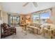 Comfortable living room with large windows, a ceiling fan, and glass sliding doors to an enclosed porch at 58 Lakeview Dr, North Port, FL 34287