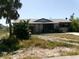 Exterior shot of the home showing the front facade with mature landscaping and a paved walkway at 7321 Bolten Ln, Port Charlotte, FL 33981