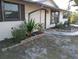 Close-up of the home's entrance showcasing a stone-lined garden bed with mature greenery at 7321 Bolten Ln, Port Charlotte, FL 33981