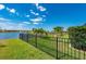 Fenced backyard with a manicured lawn and views of the community pond at 7501 Mikasa Dr, Punta Gorda, FL 33950