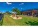 Well-maintained backyard featuring a screened lanai, decorative landscaping, and lush green grass under a bright blue sky at 7501 Mikasa Dr, Punta Gorda, FL 33950