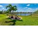 Black metal fenced backyard with decorative landscaping, lush green grass, and views of the community pond at 7501 Mikasa Dr, Punta Gorda, FL 33950