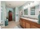 Bright bathroom featuring double sinks, ample cabinet space, and coastal-themed decor with fresh, bright lighting at 7501 Mikasa Dr, Punta Gorda, FL 33950