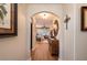 Hallway with arched entryway leading to the living room, decorated with lamps and artwork at 7501 Mikasa Dr, Punta Gorda, FL 33950