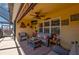Covered lanai with wicker seating, ceiling fan, and mounted television for comfortable outdoor living at 7501 Mikasa Dr, Punta Gorda, FL 33950