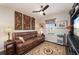 Comfortable living room with a leather sofa, decorative wall art and ceiling fan with light at 7501 Mikasa Dr, Punta Gorda, FL 33950