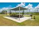 Outdoor picnic area with a large shaded table and barbecue grill near the community lake at 7501 Mikasa Dr, Punta Gorda, FL 33950