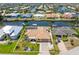 Waterfront home featuring lush landscaping, a tile roof, and a screened-in pool, located on a canal with boat dock at 931 Cimarron Dr, Punta Gorda, FL 33950