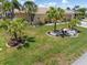 Expansive front yard with lush landscaping and mature palm trees at 931 Cimarron Dr, Punta Gorda, FL 33950