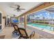 Inviting covered lanai with ceiling fans, lounge chairs and a view of the sparkling pool and canal at 931 Cimarron Dr, Punta Gorda, FL 33950