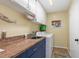 Bright laundry room featuring blue cabinets with granite countertop, washer, dryer, and ample storage space at 931 Cimarron Dr, Punta Gorda, FL 33950