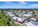 An aerial view of condo community featuring lush landscaping, lake, and nearby tennis courts at 9850 Fiddlers Green Cir # 130, Rotonda West, FL 33947