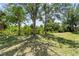 Beautiful backyard featuring mature trees providing shade on a well-maintained lawn at 9850 Fiddlers Green Cir # 130, Rotonda West, FL 33947