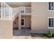 An exterior view of the condo building with stairs leading up to the second floor at 9850 Fiddlers Green Cir # 130, Rotonda West, FL 33947
