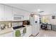 Bright kitchen with white appliances and tile floor at 9850 Fiddlers Green Cir # 130, Rotonda West, FL 33947