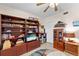 Cozy living room with built-in bookshelves, ceiling fan, and entertainment center at 9850 Fiddlers Green Cir # 130, Rotonda West, FL 33947