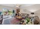 Bright living room featuring a ceiling fan, sliding glass doors to the patio, and comfortable seating arrangement at 9850 Fiddlers Green Cir # 130, Rotonda West, FL 33947