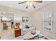Comfortable living room featuring a ceiling fan, an off-white sofa, and tile floors at 9850 Fiddlers Green Cir # 130, Rotonda West, FL 33947