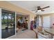Covered patio with ceiling fan, tiled floor, golf supplies, access to the main house, and views of the greenery at 9850 Fiddlers Green Cir # 130, Rotonda West, FL 33947