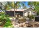 Private backyard oasis with a brick patio, fire pit, and lush landscaping at 1102 Hunt Club Ln, Valrico, FL 33594