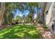 Expansive backyard with a well-maintained lawn, patio area, and tropical foliage at 1102 Hunt Club Ln, Valrico, FL 33594