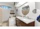 Bright bathroom with dual sinks, framed mirrors, soaking tub with tile surround and a window for natural light at 1102 Hunt Club Ln, Valrico, FL 33594