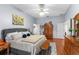 Spacious bedroom featuring wood floors, a ceiling fan, and a comfortable upholstered bed with plenty of natural light at 1102 Hunt Club Ln, Valrico, FL 33594