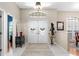 Bright foyer with tile flooring, a decorative chandelier, and an arched transom window above the double doors at 1102 Hunt Club Ln, Valrico, FL 33594