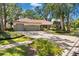 Beautiful home featuring a circular driveway, a well-maintained lawn, and mature trees providing ample shade at 1102 Hunt Club Ln, Valrico, FL 33594