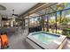 Inviting screened-in patio with a hot tub, ceiling fans, and outdoor dining area at 1102 Hunt Club Ln, Valrico, FL 33594