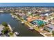 Wide aerial of waterfront home with an expansive screened-in pool, private dock, and canal access at 1134 Coronado Dr, Punta Gorda, FL 33950
