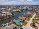 Lovely aerial perspective showcasing a beautiful waterfront home with pool, dock, and pristine landscaping at 1134 Coronado Dr, Punta Gorda, FL 33950