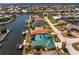 Aerial view of a waterfront property offering a screened-in pool, private boat dock, and serene canal views at 1134 Coronado Dr, Punta Gorda, FL 33950