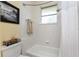 Clean bathroom featuring a tub/shower combo with tiled walls, a framed print on the wall, and a window at 1134 Coronado Dr, Punta Gorda, FL 33950