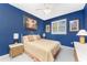 Charming blue bedroom with decorative painting, ceiling fan, and bedside tables, creating a peaceful retreat at 1134 Coronado Dr, Punta Gorda, FL 33950