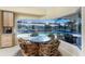 Bright dining area with water view and access to the pool area with a glass table and seating for four at 1134 Coronado Dr, Punta Gorda, FL 33950