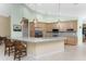 Spacious kitchen with eat-in island, light wood cabinetry, stainless appliances, and modern pendant lighting at 1134 Coronado Dr, Punta Gorda, FL 33950