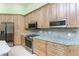 Bright kitchen featuring stainless steel appliances, light wood cabinetry and light stone countertops at 1134 Coronado Dr, Punta Gorda, FL 33950