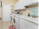 Efficient laundry room featuring modern white appliances, a sink, and ample storage for cleaning supplies at 1134 Coronado Dr, Punta Gorda, FL 33950