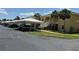 View of the condominium exterior with parking under white canopies and stairs to the second floor units at 1295 Saxony Cir # 2101, Punta Gorda, FL 33983