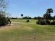 A golf cart drives along the green grass of a golf course on a clear, sunny day at 1295 Saxony Cir # 2101, Punta Gorda, FL 33983