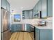 Well-lit kitchen with stainless steel appliances, teal cabinets, and modern countertop at 1318 Wesley Dr # 7, Punta Gorda, FL 33950