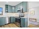 Charming kitchen featuring sleek countertops, stainless steel appliances, and teal-colored cabinets at 1318 Wesley Dr # 7, Punta Gorda, FL 33950