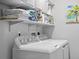 Bright laundry room with washer, dryer, shelving, and essential cleaning supplies at 1318 Wesley Dr # 7, Punta Gorda, FL 33950